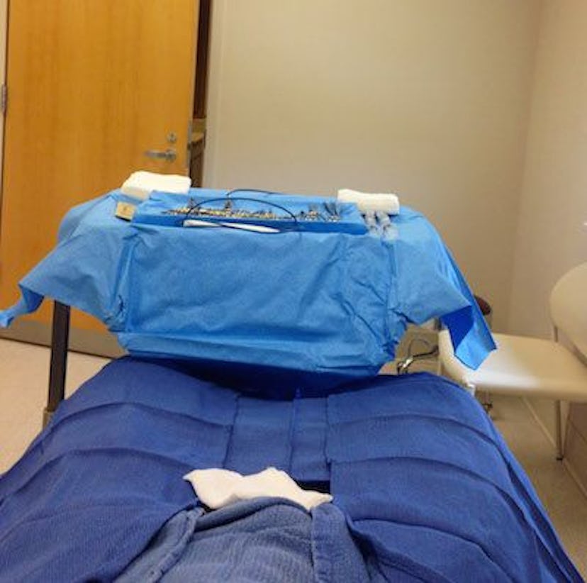 A man lying down in a hospital bed prepared to get a vasectomy.