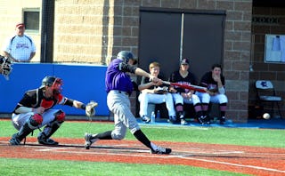 Two baseball players, one hit the ball with his bat, and the other one trying to catch it, players s...