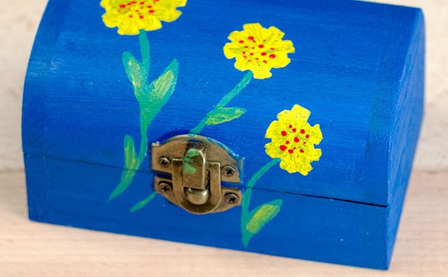 A blue box with yellow flowers that serves as a time capsule made by a mother who is facing a conund...