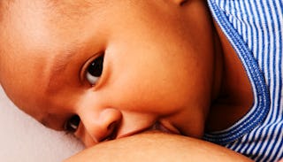 A mother who is breastfeeding her child in a blue-white striped shirt