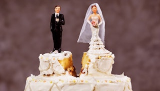 A wedding cake with little figures of the couple, split in half representing divorce