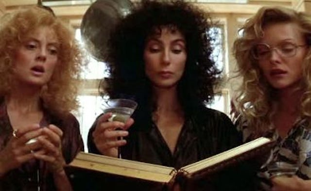 Alex, Jane, and Sukie from The Witches of Eastwick reading a book with shocked facial expressions
