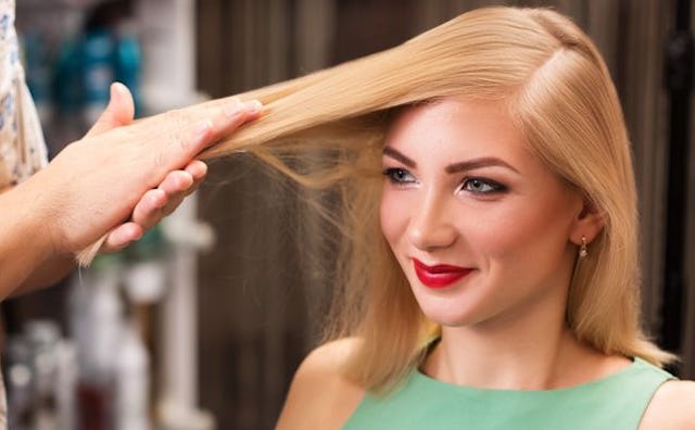 A hairdresser preparing a blonde woman's hair for a blow out