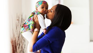 Mother kissing her newborn