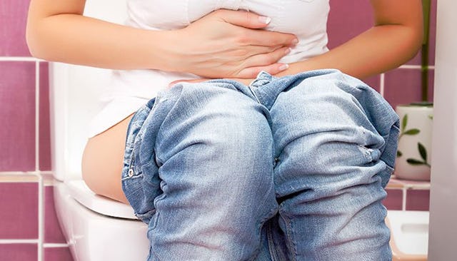 Woman sitting on a toilet bowl