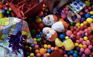 Kinder Surprise eggs in a large pile made of various types of candies