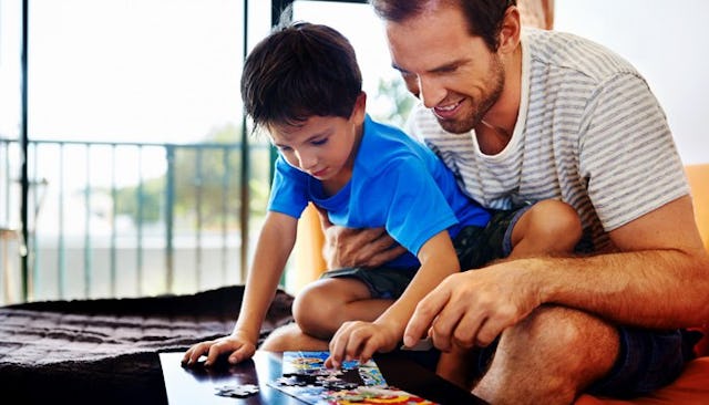 A stay-at-home dad and his son playing with puzzles