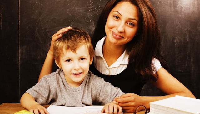 A young brown-haired mother smiling with her son after reading a back-to-school letter from a teache...