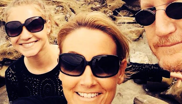 A selfie of a girl, her stepmother and her father with all three of them smiling