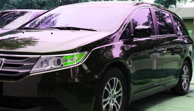 A black minivan parked on the road