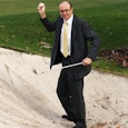A man playing golf dressed in a suit