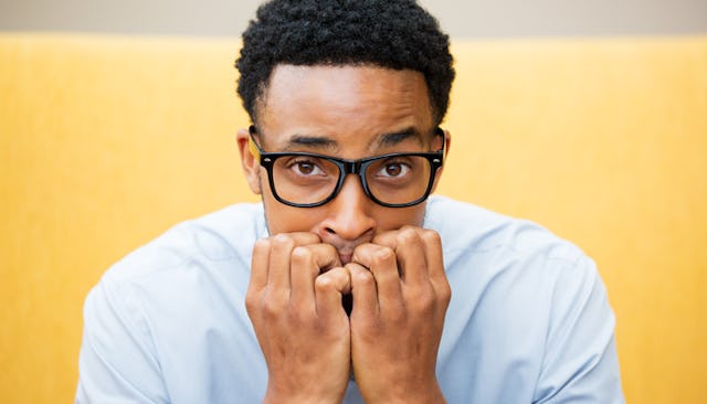 A man with his hands on his mouth, anxious about getting a vasectomy