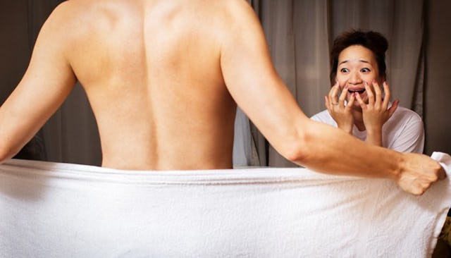 A woman screaming while her husband removes his towel.