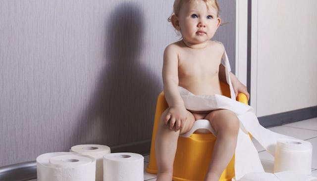 A kid who is being potty trained playing with some toilet paper