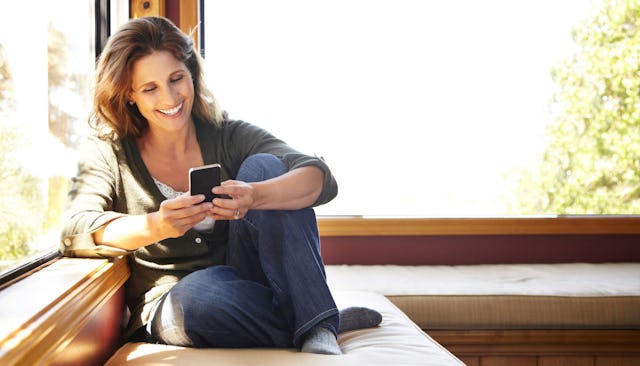 woman-smiling-looking-at-smartphone