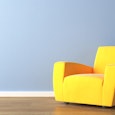 Big yellow armchair in a room.