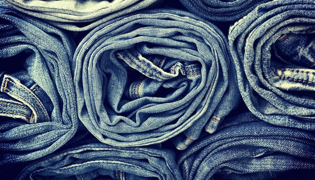 A stack of rolled-up blue denim mom jeans