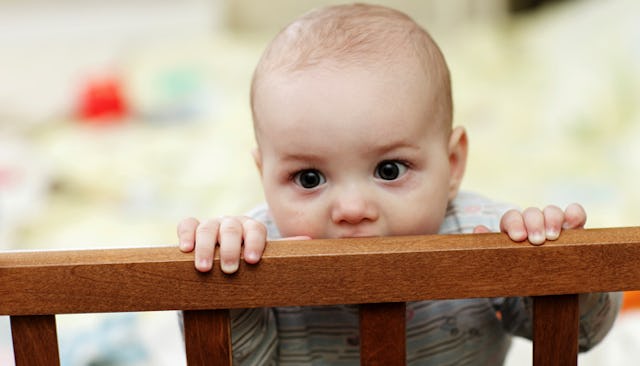 Baby standing in a bed