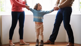 Divorced parents grabbing their daughter's hands in a love-hate custody