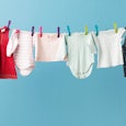 Children's clothes in various colors drying on a rack