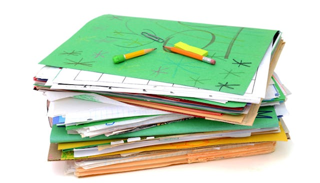 A lot of green and yellow paper files stacked on top of each other and two pencils on top of it