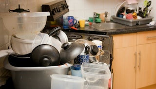 A pile of dirty dishes placed on a kitchen's countertops