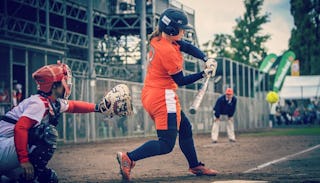 Two female children with a coach watching them play sports