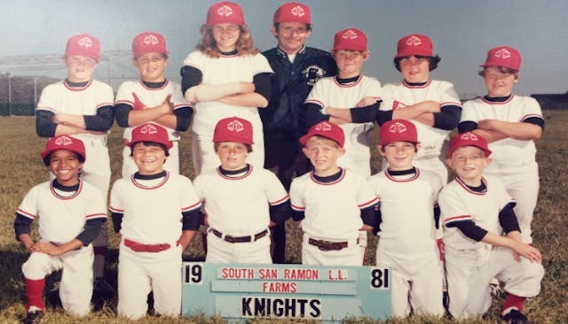 A baseball team of thirteen kids with one girl on the team