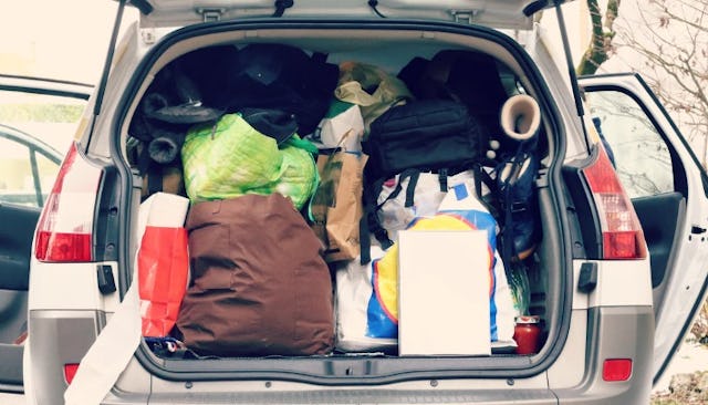 A car with a trunk filled to its maximum capacity with luggage with all doors opened for travel