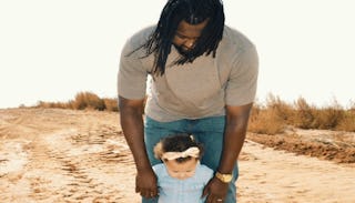 A father walking with his daughter in the desert