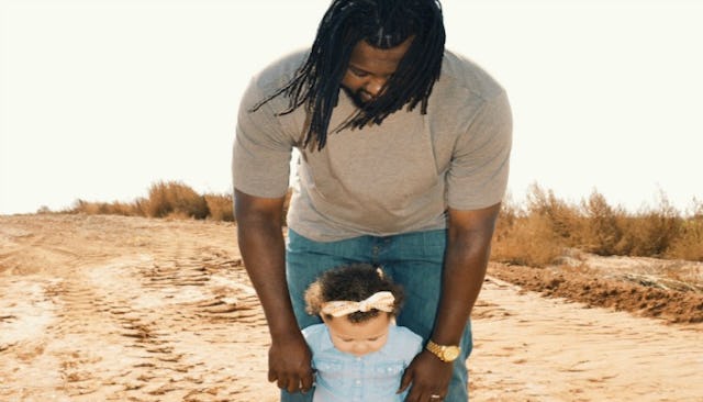 A father walking with his daughter in the desert