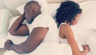 Wife and husband lying on a memory foam mattress in their bed 