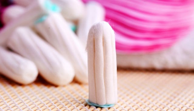 A tampon and a few tampons stacked behind, slightly blurred.