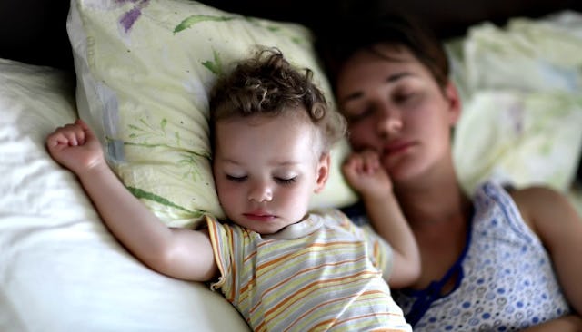 Cute baby peacefully sleeping next to mother