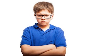 A mad-looking boy wearing glasses and a blue polo t-shirt