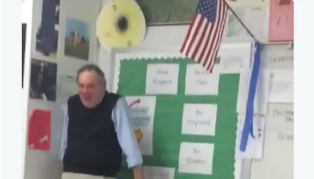 Blurry image of a teacher standing in a corner of his classroom while being surprised by his student...