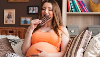 pregnant woman sitting, pregnant woman eating, woman touching pregnant belly