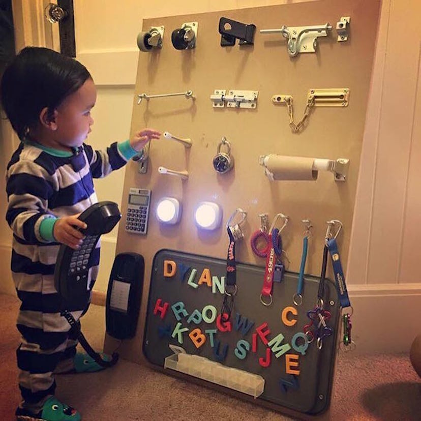 A toddler playing with a DIY Project sensory board