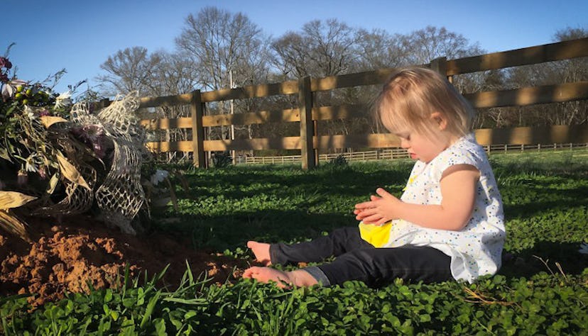 A baby sitting on the ground and playing