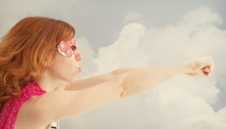 A woman posing with her hands up, as she feels like a strong mom