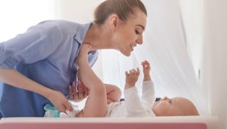 A mother changing the diapers of her newborn baby