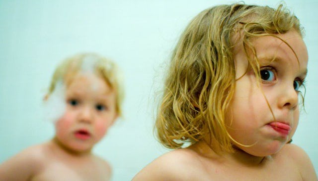 A toddler girl and a boy in a bath