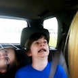 A mother in a car with her son and daughter who are making weird faces.