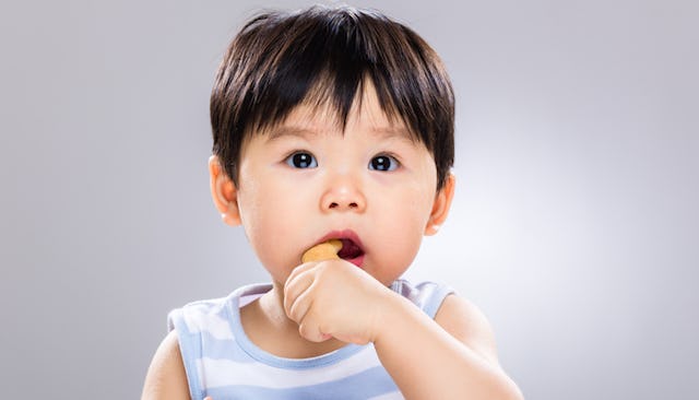 Baby eating food with her fingers