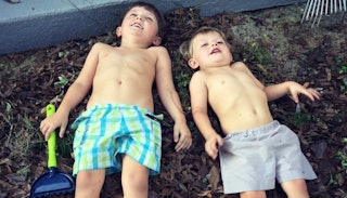 Two little boys with sensory processing disorder laying on the ground and playing