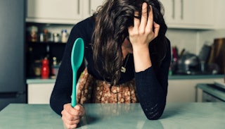 Woman in the kitchen, desperate and too tired to be a mom