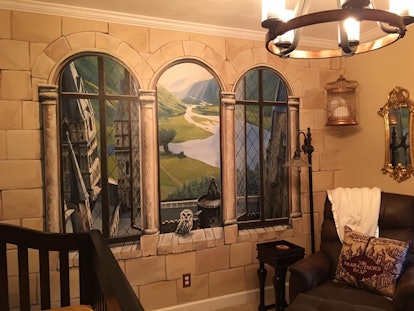 Painted windows with Hogwarts landscapes on a wall in a 'Harry Potter' inspired nursery