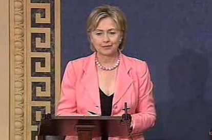 Hilary Clinton giving a speech while wearing a pink pantsuit and a black top