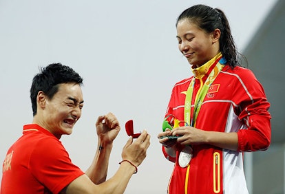 Qin Kai signaling to the crowd that Zi said yes. Image via Clive Rose/Getty Images.