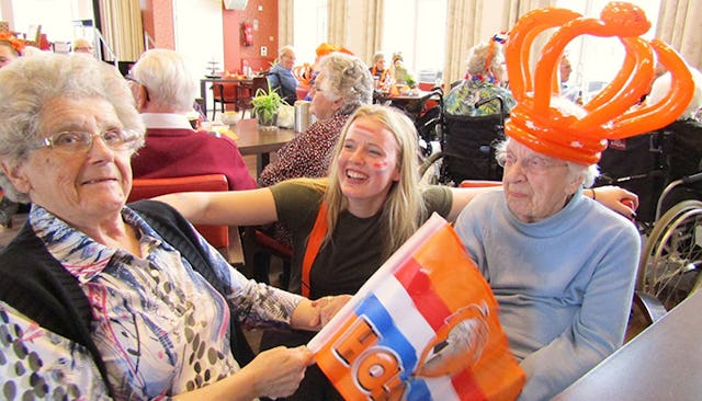 Two elderly ladies and a college student spending time together in a nursing home